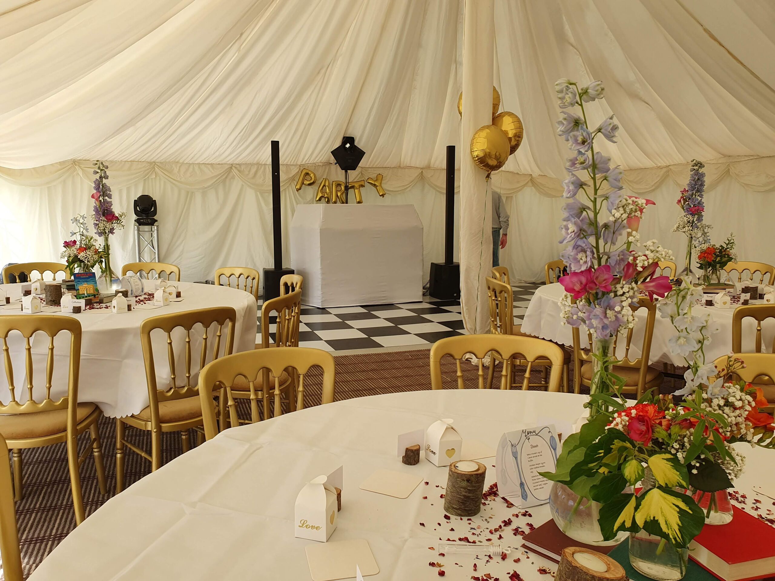 Wedding disco set up in a marquee with chequerboard dance floor